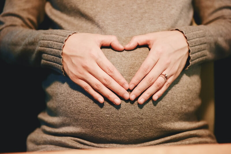 un femme enceinte tenant son ventre