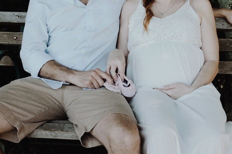 couple tenant des petits chaussons de bébé