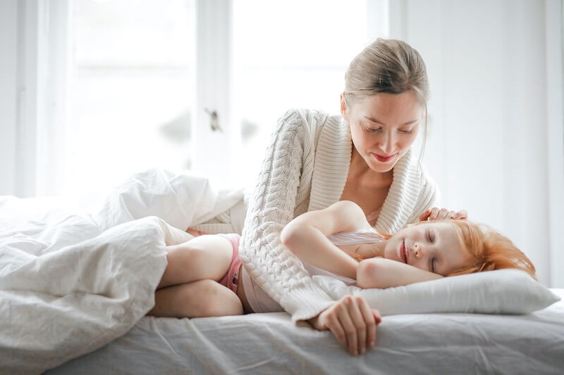Une femme et son enfant allongé sur le lit